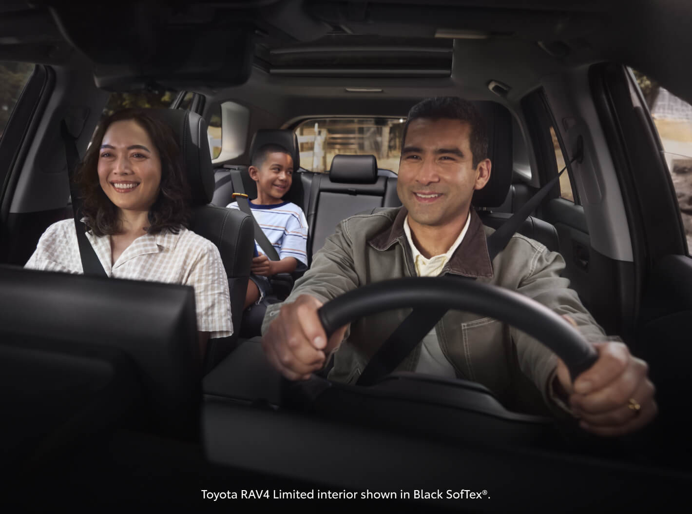 Interior view showcasing a family riding inside a Toyota RAV4 Limited with Black SofTex seats.