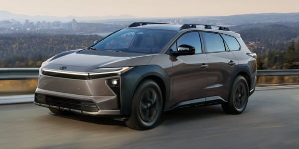 Gray Toyota bZ Woodland driving on a road, shown from a front three-quarter view.